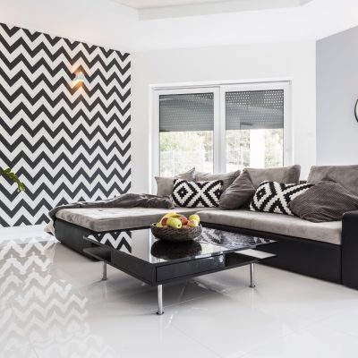 Posh living room with white tiled floor and black lounge set